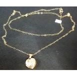 Yellow metal small gold heart locket with fine yellow metal chain, weight 1g approx.