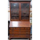 George III mahogany large bureau bookcase, the moulded dentil cornice over a pair of astragel glazed