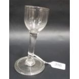18th Century cordial glass of plain form with slightly domed fold over foot, leaning slightly to one
