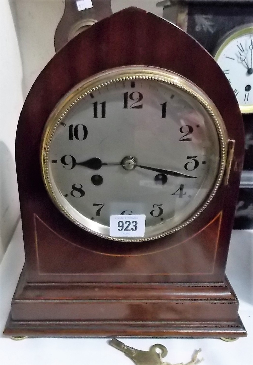 Two train mantel clock with mahogany inlaid lancet case, the silvered dial with Arabic numerals, the