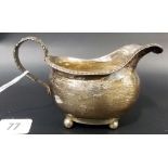 George III silver milk jug, of oval section with gadrooned rim & foliate scroll handle raised on 4