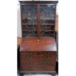 George III mahogany bureau bookcase, the moulded dentil cornice over a pair of astragel glazed