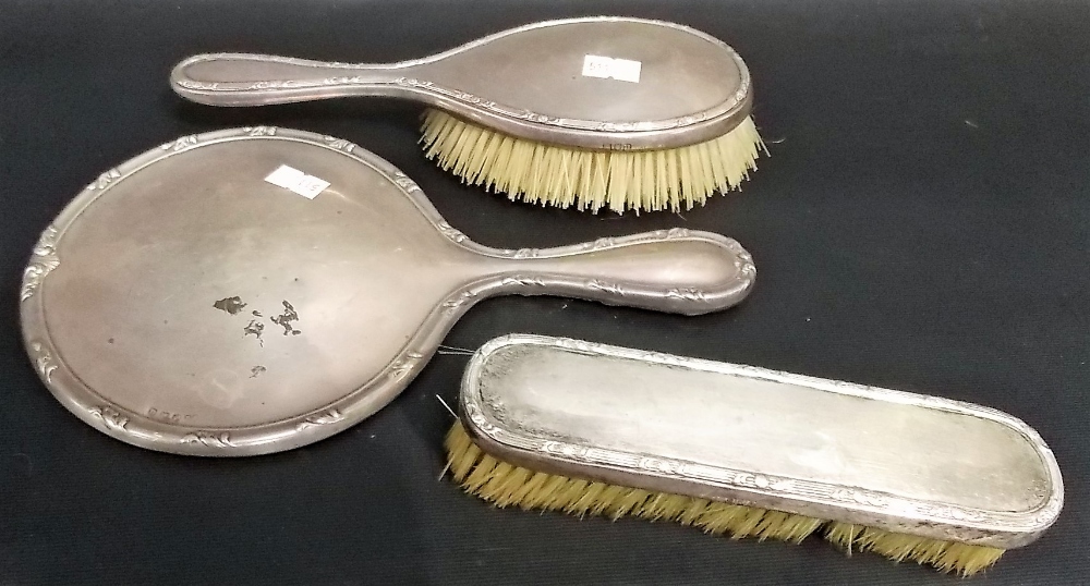 Pair of George V silver dressing table brushes, London 1915; together with a silver hand mirror (