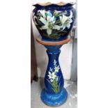 Watcombe Pottery, Torquay jardiniere on stand, decorated with lilies upon a blue ground, incised