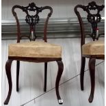 Set of six Edwardian mahogany salon chairs with foliate carved and scroll backs upon cabriole