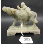 Carved green jadite group depicting a boy on the back of a water buffalo upon a rectangular base,