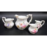 Four Royal Crown Derby graduated jugs, painted with floral sprays and with gilt highlights, the