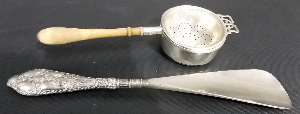 Silver tea strainer with turned wood handle, Birmingham 1957; together with a silver handled shoe