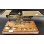 Early 20th Century brass postal balance scales with 6 bell shaped weights upon rectangular base