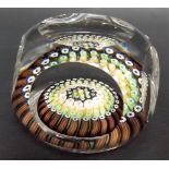 Millefiori glass paperweight with green, brown, yellow and white canes encased in clear circular