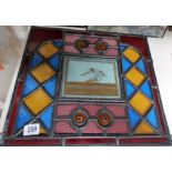 Stained leaded glass panel, the central rectangular panel painted with a long-jumper and