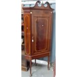 George III mahogany inlaid corner cupboard with swan neck pediment on later stand.