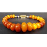 Butterscotch amber bead bracelet with gold and enamel clasp, the beads of graduated circular
