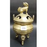 Oriental brass lidded censer, the lid with seated fo dog, the ovoid body raised on triple mask