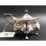 Edwardian silver mustard pot of hinge lidded lobed form, raised on four outswept feet, blue glass