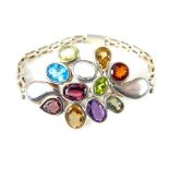 Contemporary multi stone designer bracelet, garnet, peridot, citrine, amethyst & blue topaz set in