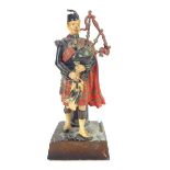 Scottish pipe major figure with bagpipes match striker, c1930, 19.5cm h