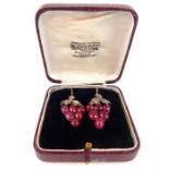 A pair of antique diamond and ruby grape earrings in a presentation box.