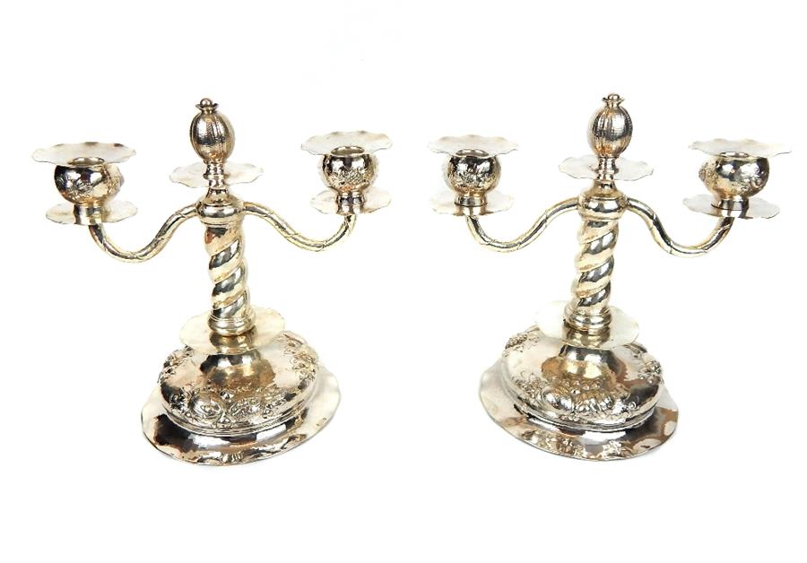 A pair of silver twin branch candelabra with pomegranate on hollow feet with repousse fruit