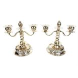 A pair of silver twin branch candelabra with pomegranate on hollow feet with repousse fruit