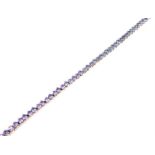 An 18 ct white gold and pale amethyst-coloured stone tennis bracelet