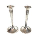 Liberty & Co; a pair of George V silver candlesticks