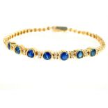 An 18 ct yellow gold, diamond and sapphire seven stone bracelet, Length 19 cm / 7.09 '' Gross weight