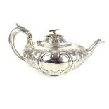 A Victorian silver teapot with exquisite repousse decoration