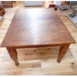 An early 20th oak rectangular extending dining table with four additional pine leaves