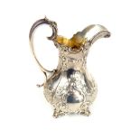 A Victorian silver milk jug with repousse decoration