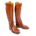 A pair of tan leather John Lobb Ltd calf length lace up boots, complete with boot trees