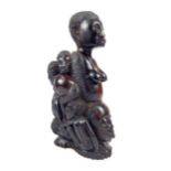 A 19th century carved African possibly Nigerian,rosewood figure of a lady with children climbing