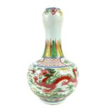 A Chinese porcelain bottle vase, decorated in the Woucai palette on green celadon ground, of