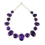 A designer necklace set with cabochon amethysts set in silver, (largest amethyst approx 3.2 cm),