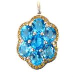 A large silver, blue topaz and citrine floral shaped pendant set with seven oval faceted topaz