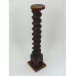 An antique carved olive press screw, converted to a jardiniere stand.