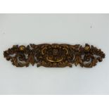 An antique Italian gilt wood panel, ornately carved with flowers, C scrolls and acanthus leaves,