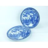 A pair of Japanese blue and white porcelain dishes, transfer printed with images of figures in a