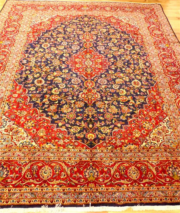 A central Persian Kashan carpet, having a red medallion on a dark blue field