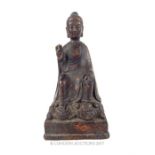 A Chinese bronzed figure of the seated Guan - Yin, with her right hand raised, bearing four