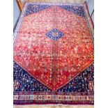 A southwest Persian Abadeh carpet, having a midnight blue lozenge on a red field