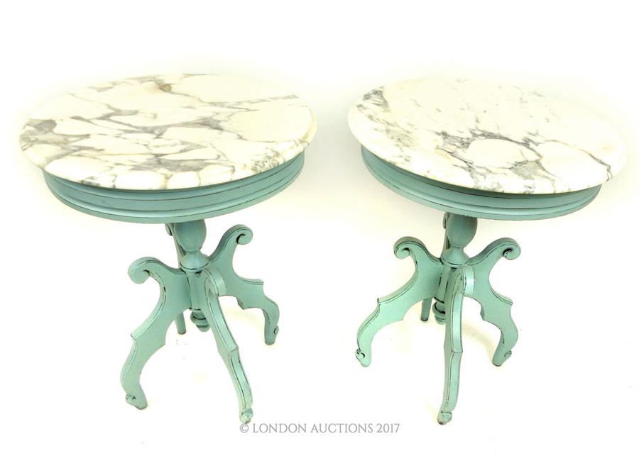 A pair of painted mahogany marble inset circular tables, raised on four shaped outswept supports, 74