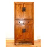 A Chinese hardwood hall cabinet, with two cupboard doors above two short drawers above a pair of