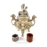 A Chinese white metal twin handled incense burner, the pierced lid cast with a model of a dragon and