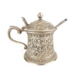 A late 19th century Indian silver mustard pot and spoon, with chased floral decoration, 7.5cm high