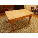 A rectangular pine kitchen table raised on turned supports