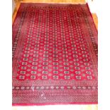 A Bokhara design carpet with repeating gul motifs on a red ground