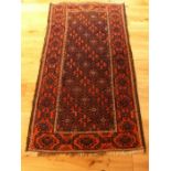 A Persian rug with repeating floral design on the midnight blue field surrounded by one frieze and