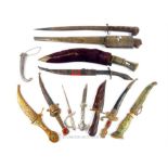 A group of various 19th century and later mainly Indian ceremonial daggers, some inset with coloured