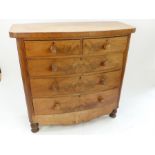 A late Victorian mahogany bow fronted chest of two short over three long drawers, raised on turned